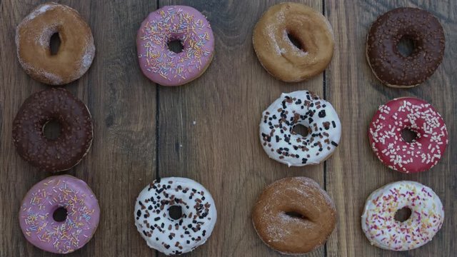 4k Donuts Composition on a Wooden Background with a Bite