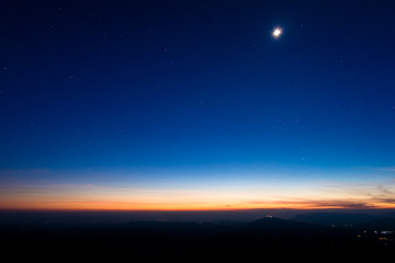 Fototapeta na wymiar night sky with moon before sunset on mountain at Phu ruea of thailand for background