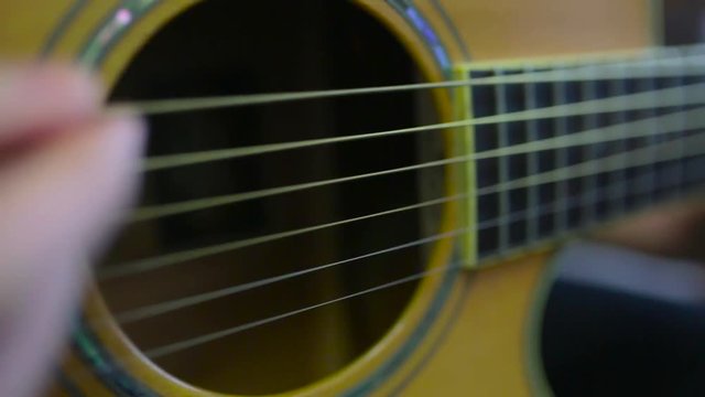 Closeup of the hands of a young man playing guitar