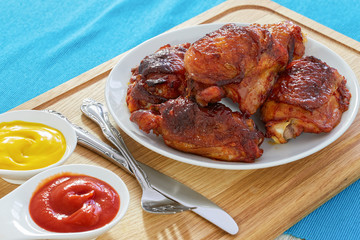 fried chicken thigh on white plate on cutting board
