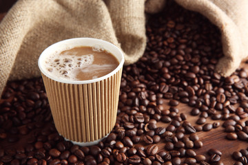 Cup of coffee with beans on table