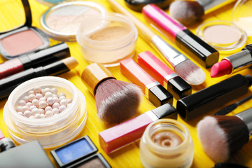 Flat lay of makeup cosmetics on yellow background