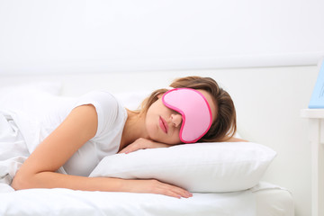 Fototapeta premium Young attractive woman sleeping in bed with eye mask