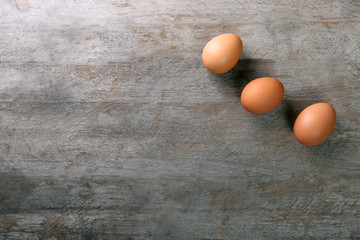 Raw eggs on wooden background