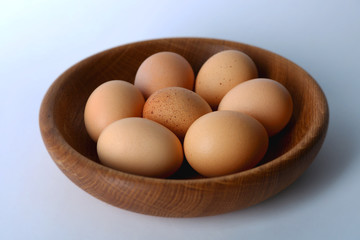 Raw eggs on plate on white background
