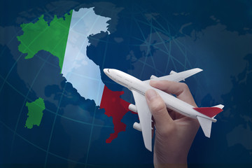 hand holding airplane with map of Italy.