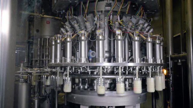 Plastic bottles filling with milk. Milk and milk products production line. 4K.