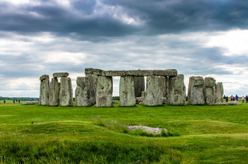 Slaughter Stone and Stonehenge underneath a dramatic sky at Salisbury, Wiltshire
