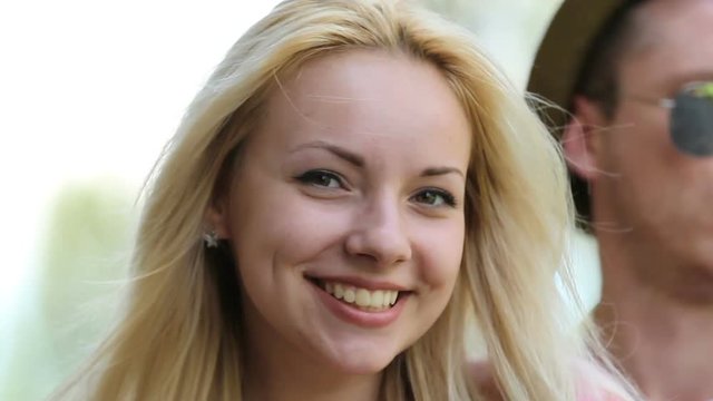 Beautiful blond girl with perfect skin smiling at camera, sunglasses off and on