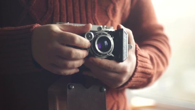 Vintage photo camera in the hands of