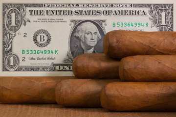 Luxury Cuban cigars with US dollar on the wooden desk .