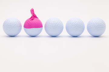 White golf balls with funny cap on the white background.