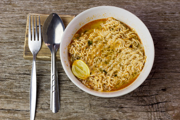 Instant noodles in wooden bowl on wood background