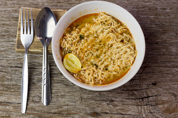 Instant noodles in wooden bowl on wood background