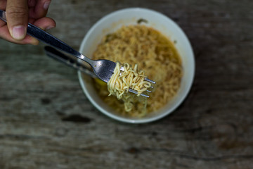 Instant noodles in wooden bowl on wood background