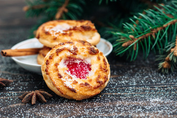 Cookies with a raspberry filling with cinnamon on wooden background Christmas theme