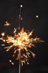 Bright festive sparkler on black background