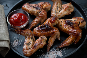 Close-up of barbecued chicken wings served in a frying pan