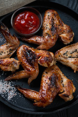 Grilled chicken wings served with sesame, sauce and sea salt