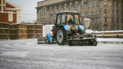 tractor cleans snow. Park snow removal on the streets with the help of special equipment