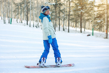 Fototapeta na wymiar female snowboarder snowboarding down the mountain