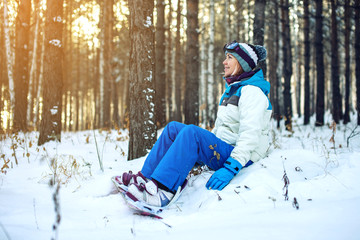 Fototapeta na wymiar woman snowboarder with snowboard is resting sitting on the snow