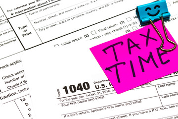 Tax time written on a bright sticker note paper clip for a tax