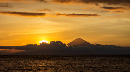 Naklejka na ściany i meble Sunset landscape with panoramic view of Bali Island and Agung Volcano mountain taken from Lombok Island, Indonesia