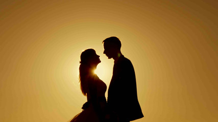 Silhouette kissing at sunset bride and groom