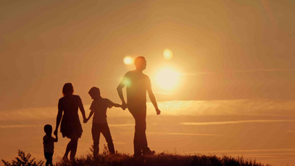 Fototapeta premium happy family at sunset silhouette of the water