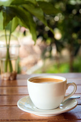 Fototapeta premium cup of fresh coffee with coffee beans on wooden table