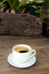 cup of fresh coffee with coffee beans on wooden table