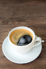 cup of fresh coffee with coffee beans on wooden table