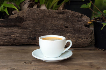 cup of fresh coffee with coffee beans on wooden table