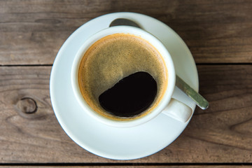 cup of fresh coffee with coffee beans on wooden table