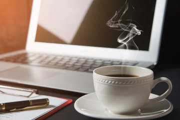 cup of coffee and laptop on the table