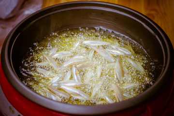  close up of fried small fish in pan sale at asian street market ,cooking style asian, asian kitchen