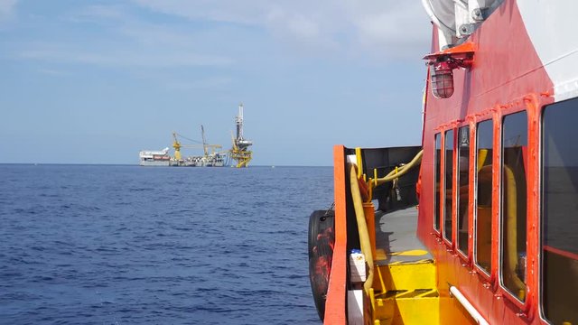 Crew boat sailing to the tender drilling rig in the middle of the ocean
