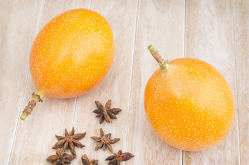 Granadilla on the wooden table (Passiflora ligularis)