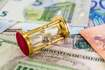 Golden hourglass on the different banknotes