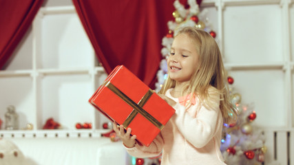 Obraz na płótnie Canvas Little girl enjoys gift for the New Year