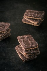 Few chocolate biscuits in stack on dark tray