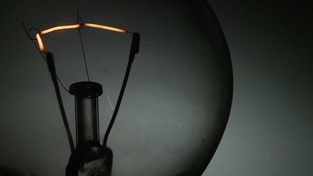 Dettaglio di una vecchia lampada al tungsteno che si accende e si spegne con intermittenza veloce.