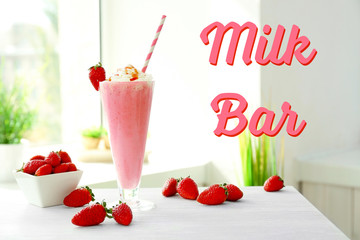 Glass of tasty milk shake on table. Text MILK BAR on background