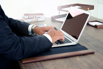 Male lawyer working with laptop in office, close up view