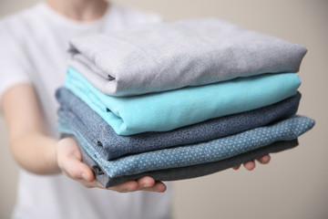 Woman holding folded clothes in hands, closeup