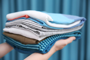 Woman holding folded clothes in hands, closeup