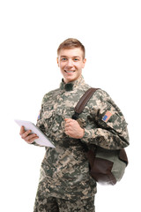 Soldier in camouflage with tablet computer and bag, on white background