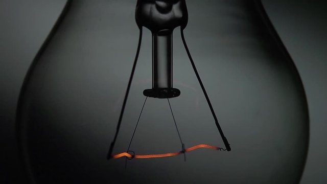 Dettaglio di una vecchia lampada al tungsteno che si accende e si spegne con intermittenza veloce.