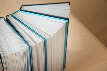 Open books in row on wooden table, closeup